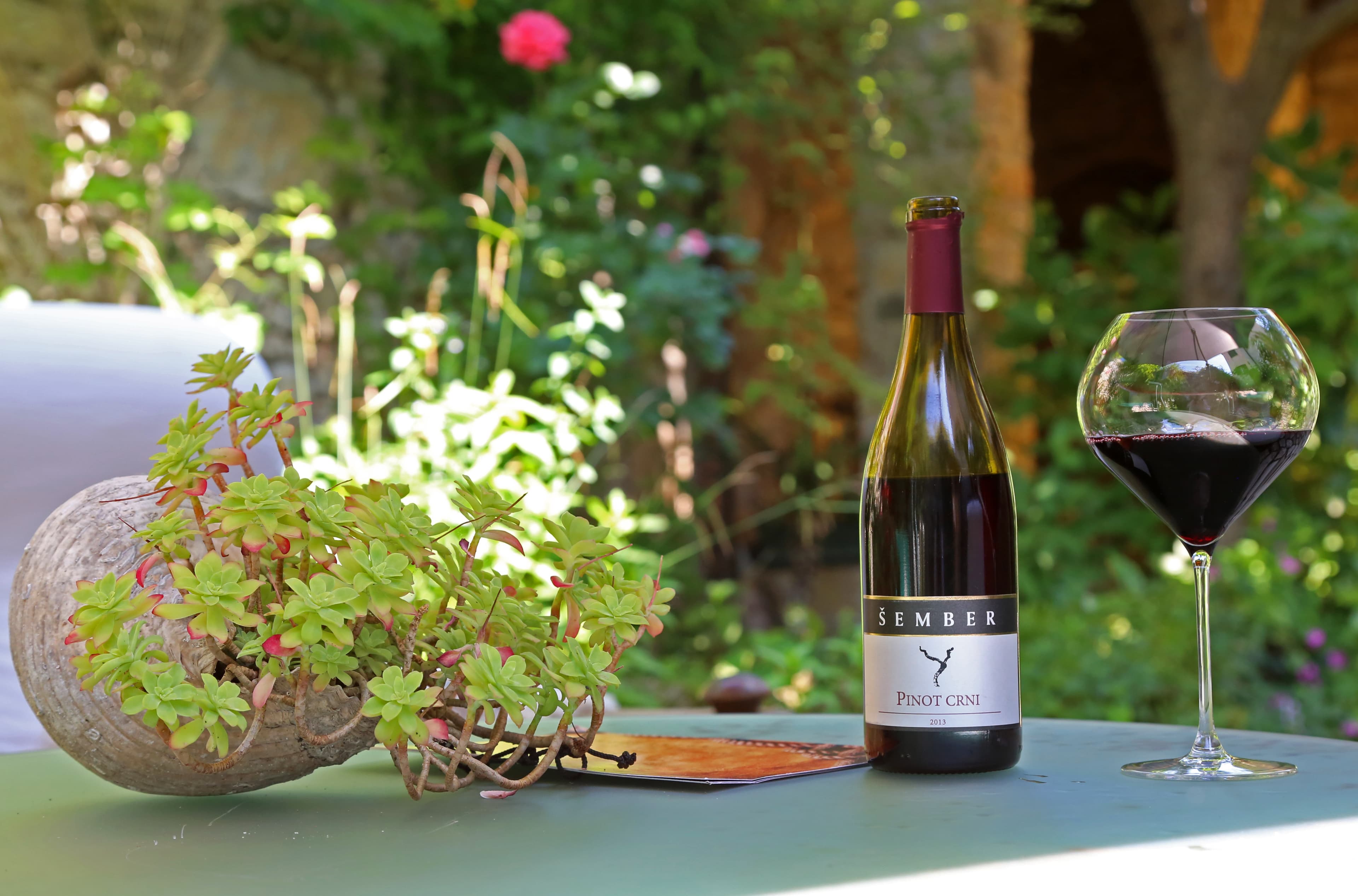 Vrt Wine Garden Skradin noću — svjećice, zelenilo, kameni zidovi