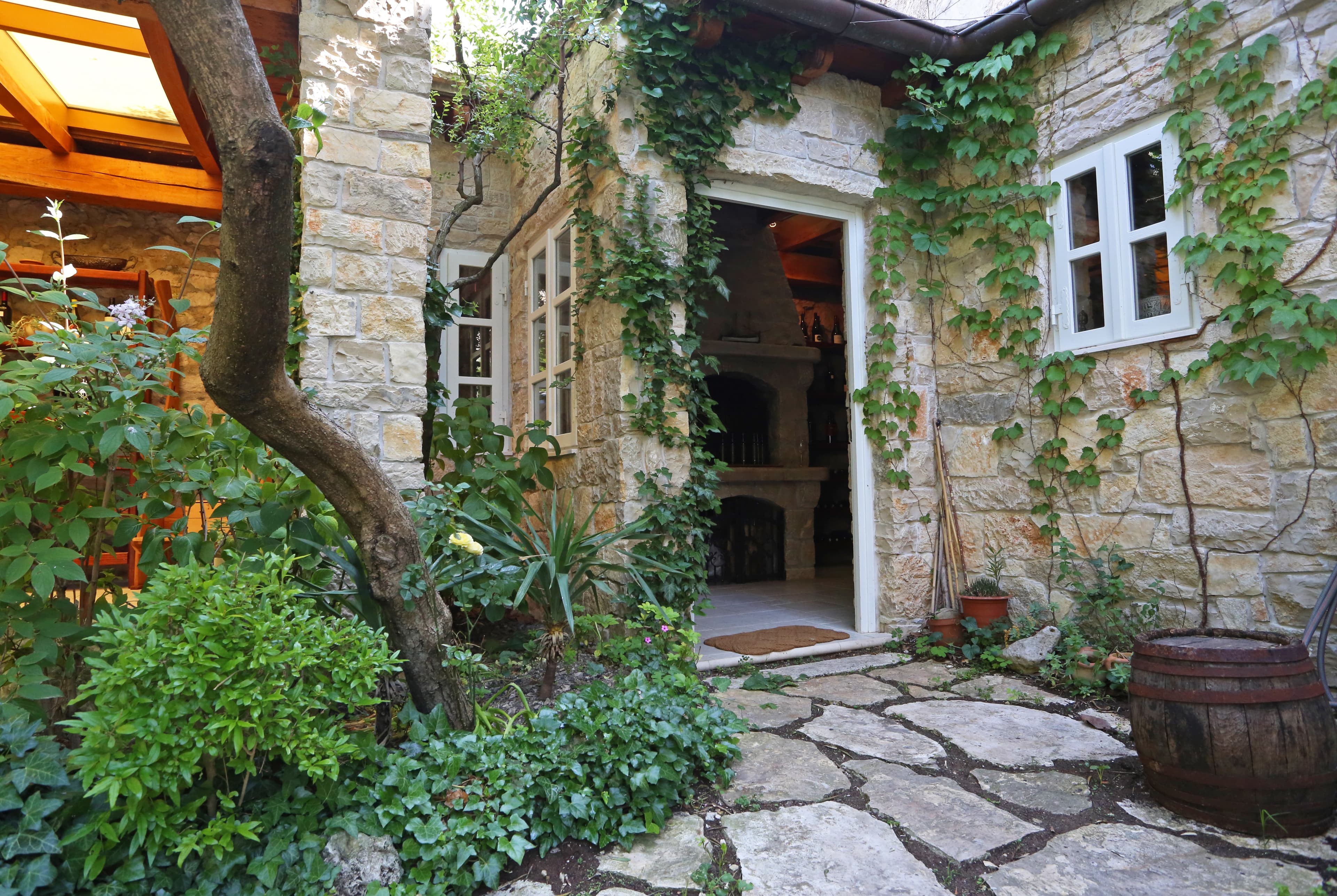Ulaz u Wine Garden Skradin — kamena kuća obraštena zelenilom, kao iz bakine priče